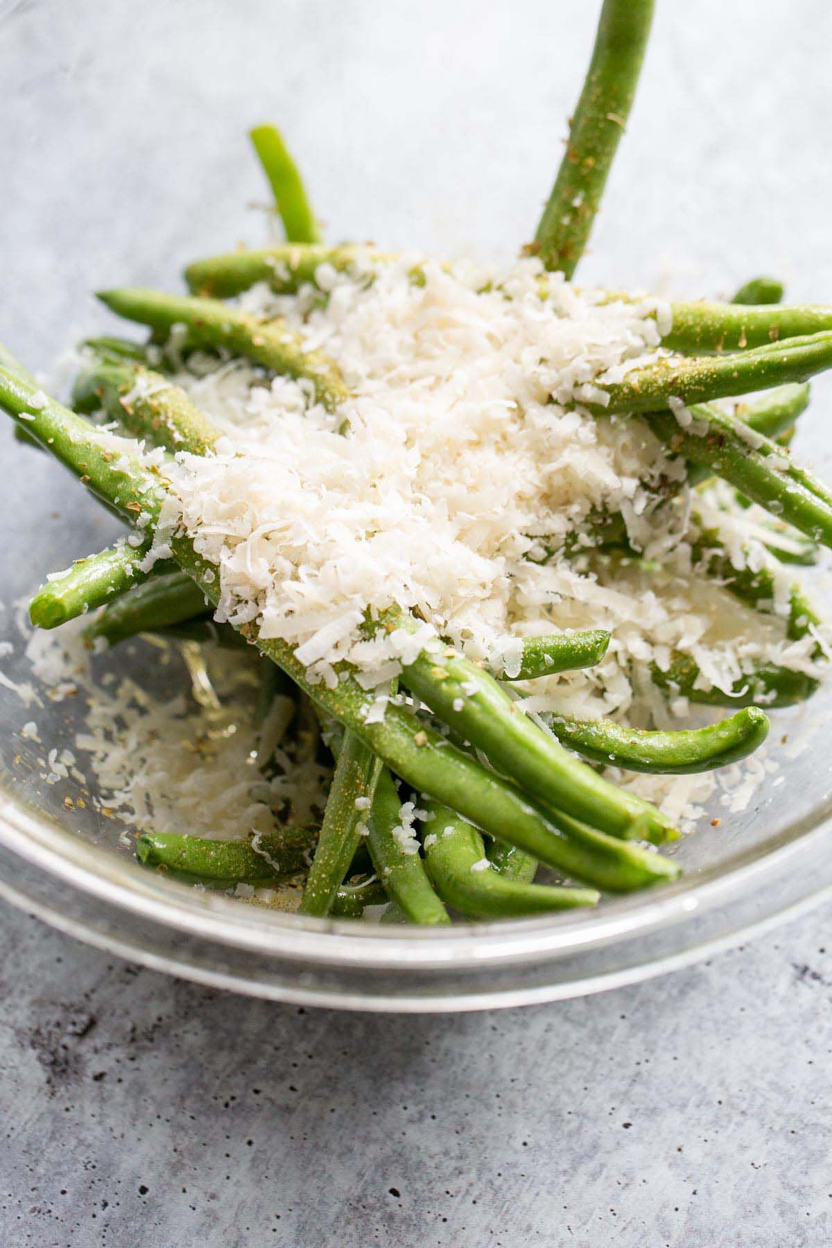 Green beans in a bowl with parmesan cheese.