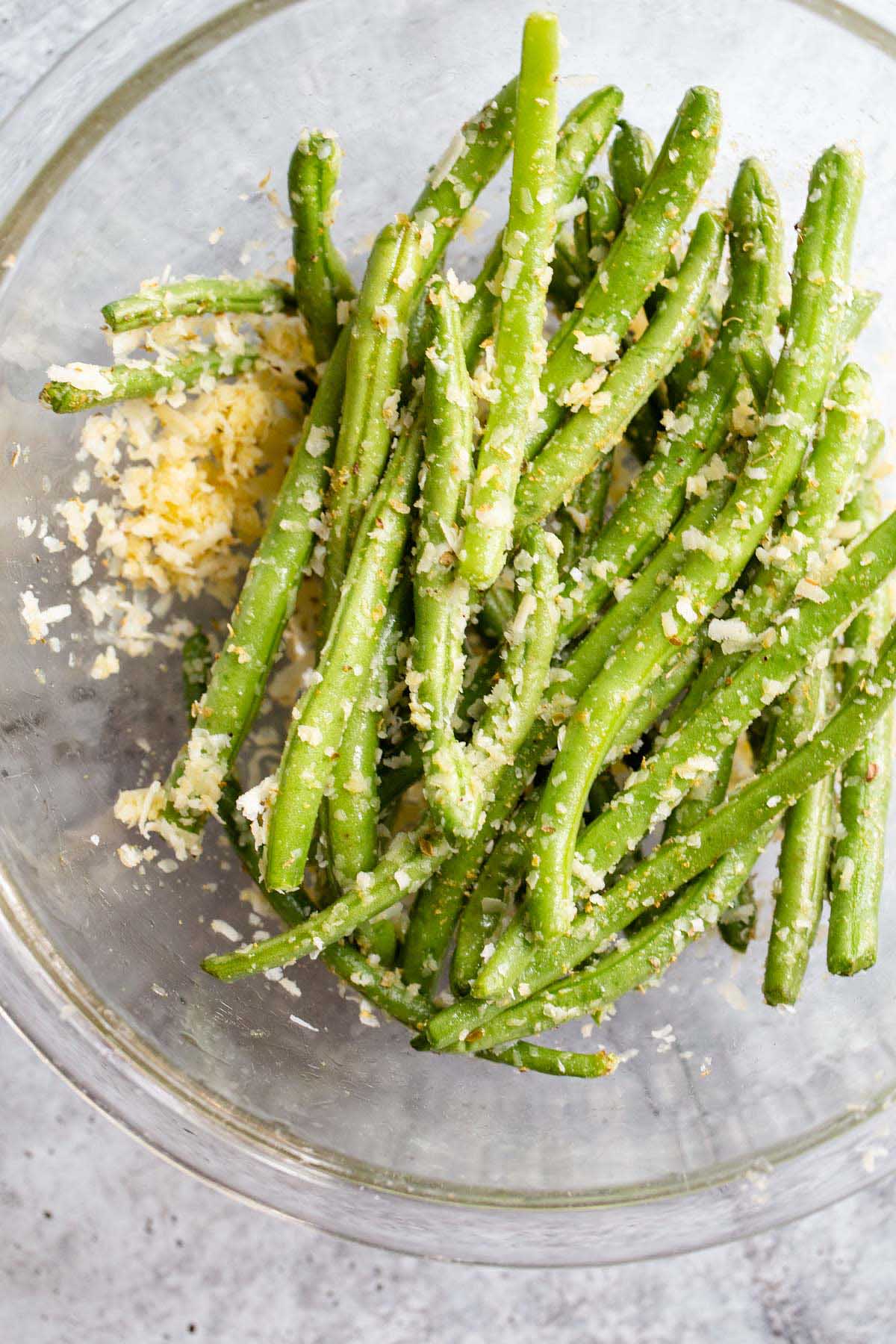 Green beans tossed with parmesan cheese in a bowl.