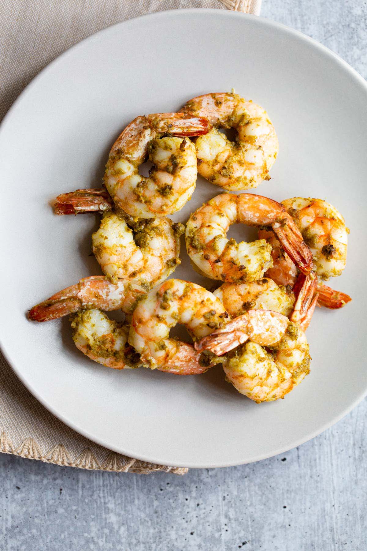 Cooked pesto shrimp on a plate.
