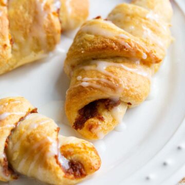 Pumpkin crescent rolls on a white plate.