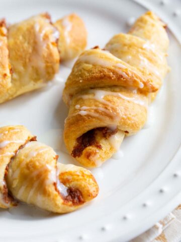 Pumpkin crescent rolls on a white plate.