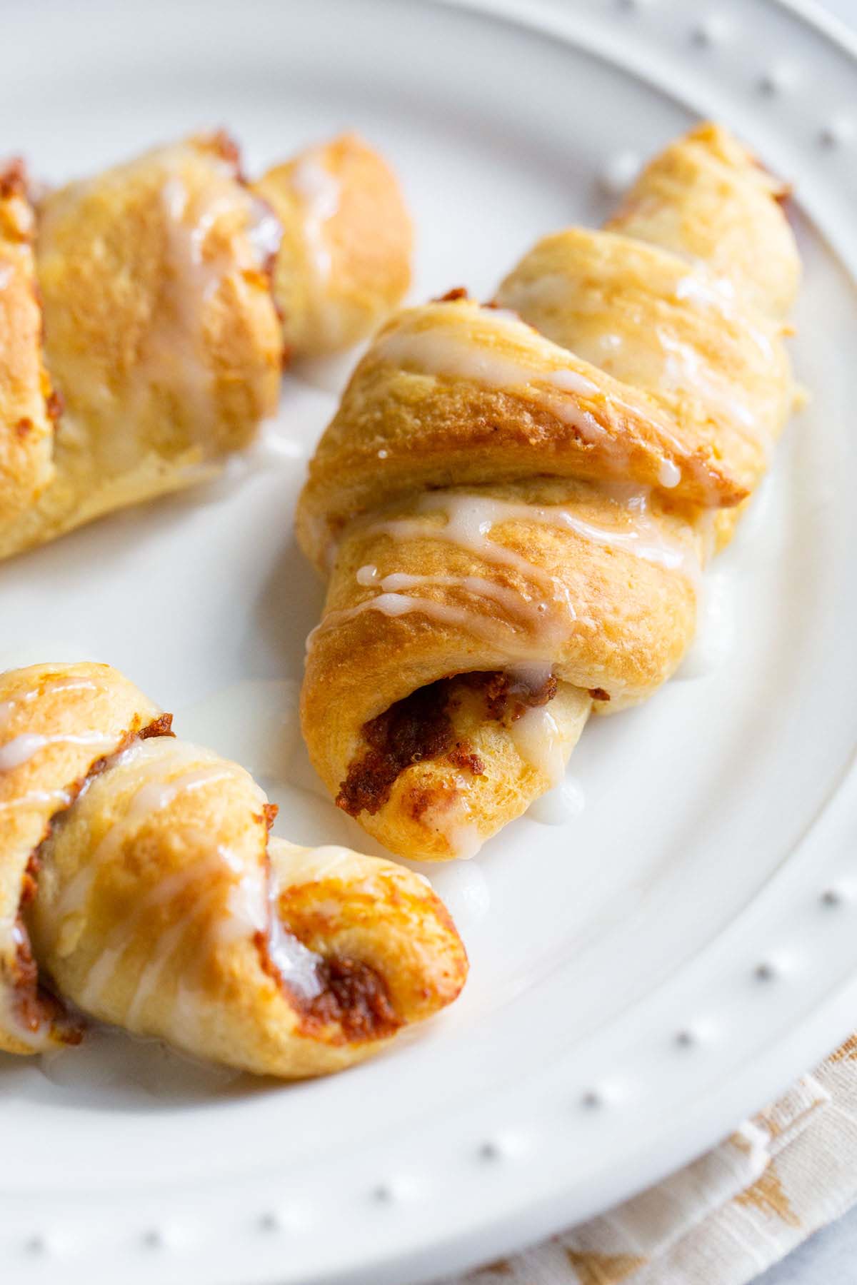 Pumpkin crescent rolls on a white plate.