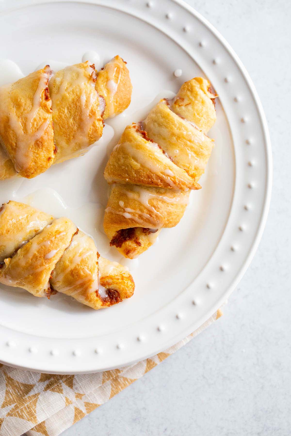 Pumpkin crescent rolls on a white plate.