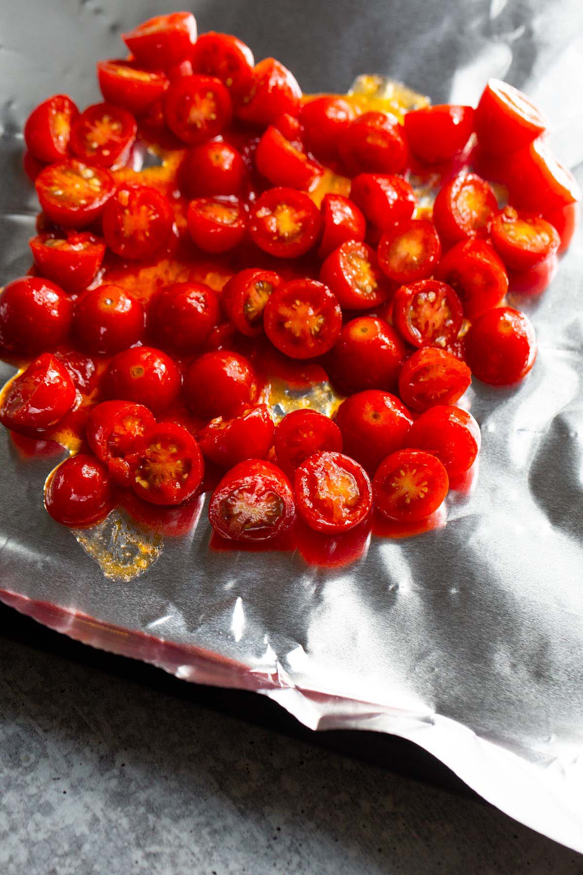 Uncooked cherry tomatoes on a baking sheet.