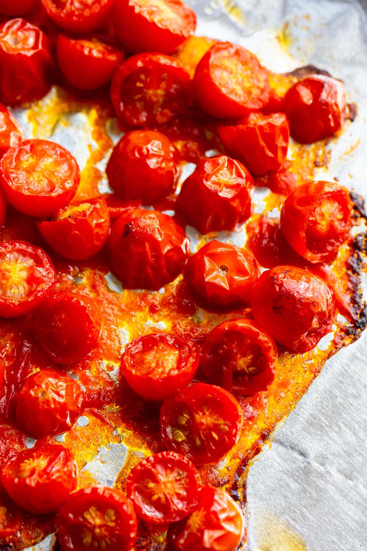 Roasted cherry tomatoes on a baking sheet.