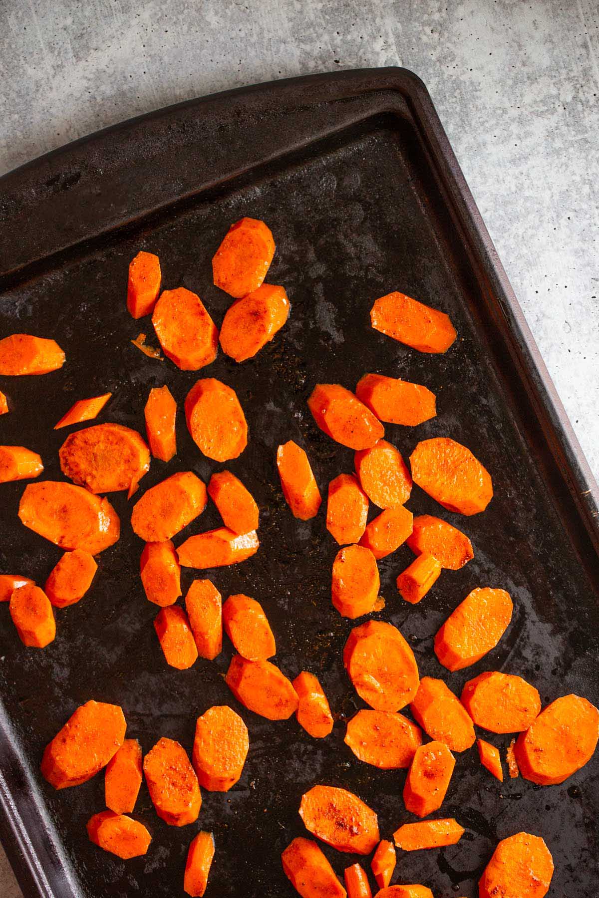 Raw carrot slices on a sheet pan.