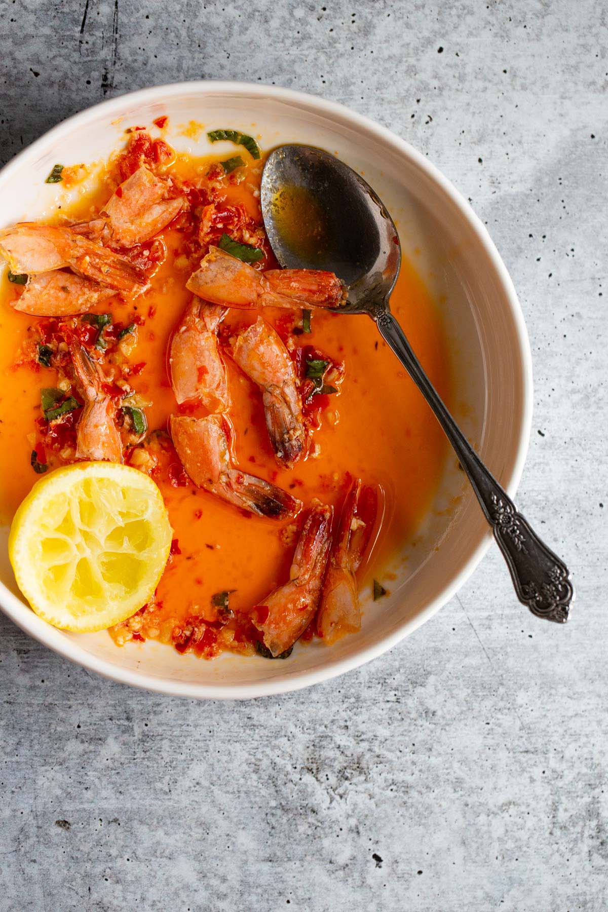 Leftover shrimp tails in a bowl of calabrian sauce.