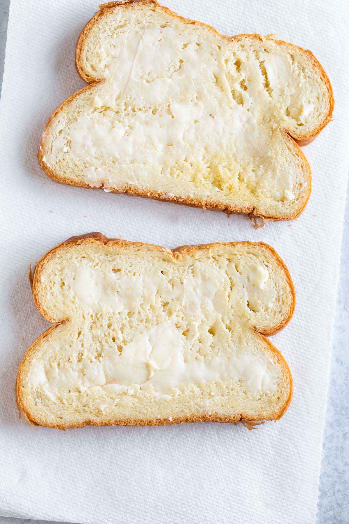 Butter spread on two slices of brioche.