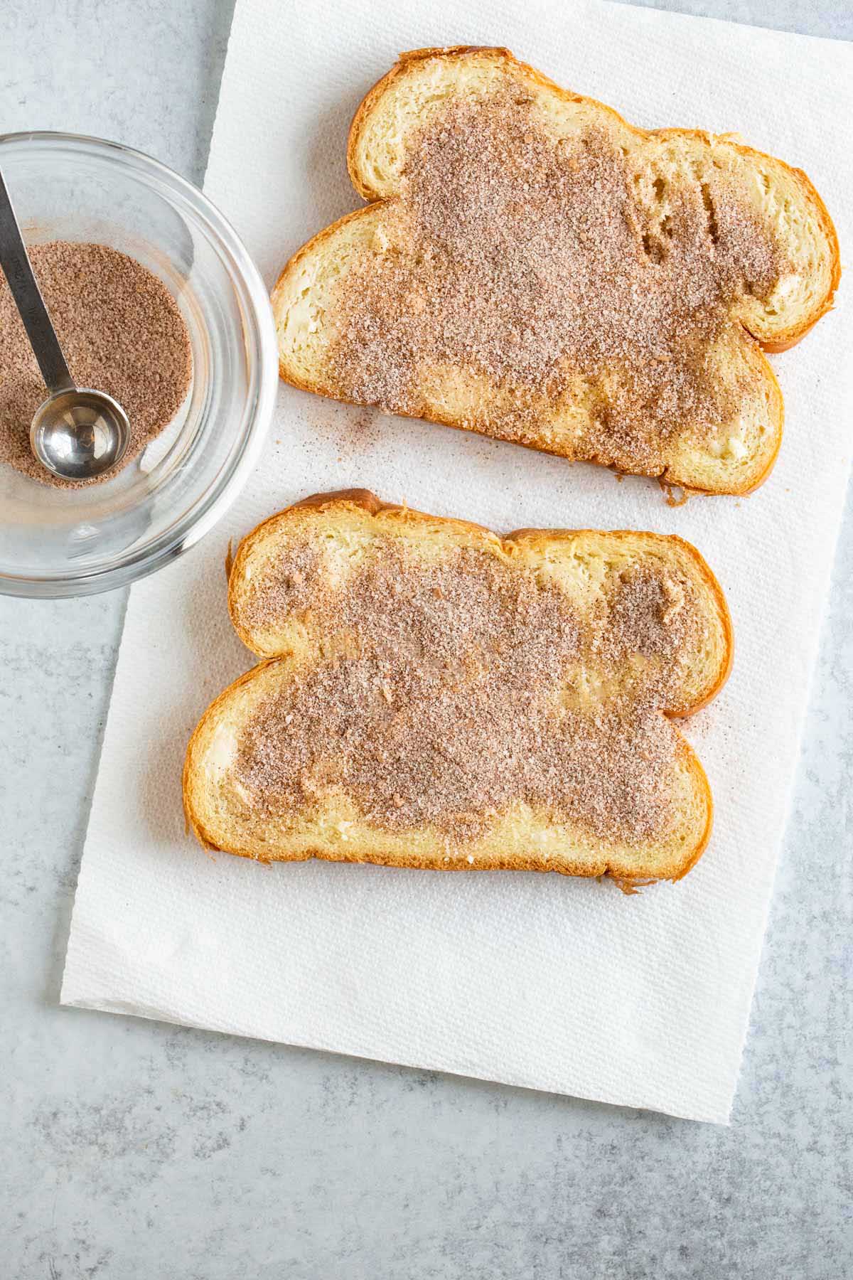 Sprinkling cinnamon sugar on bread.