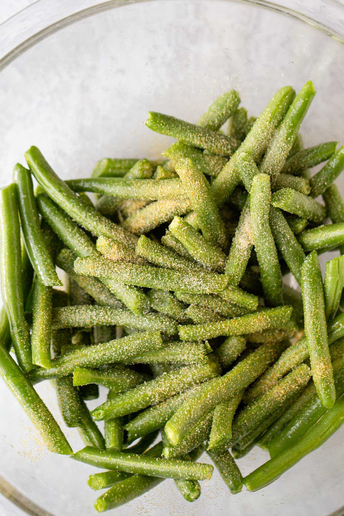 Seasonings being added to green beans.