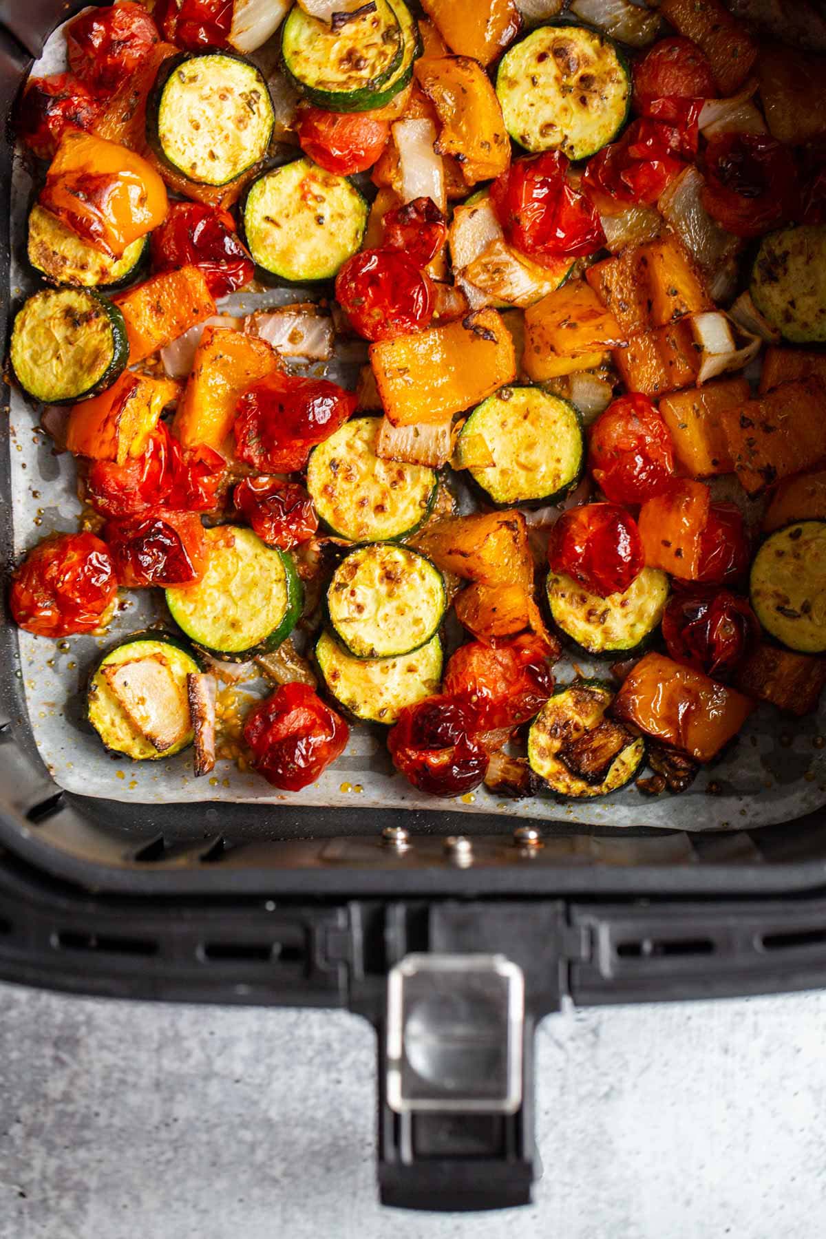 Air fryer vegetables in air fryer basket.