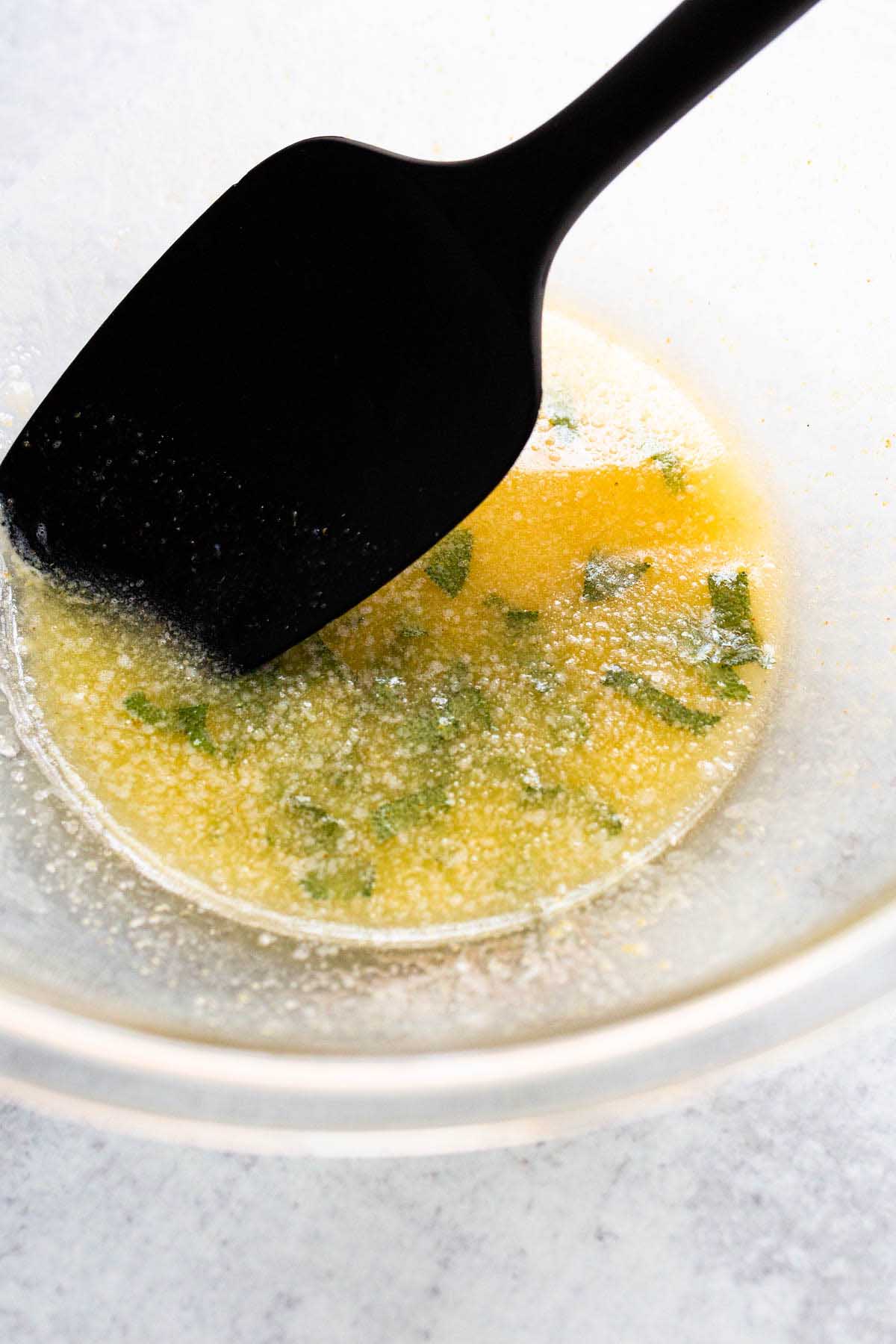 Melted butter and sage in a bowl.