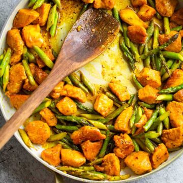 Turmeric chicken and asparagus in a skillet.