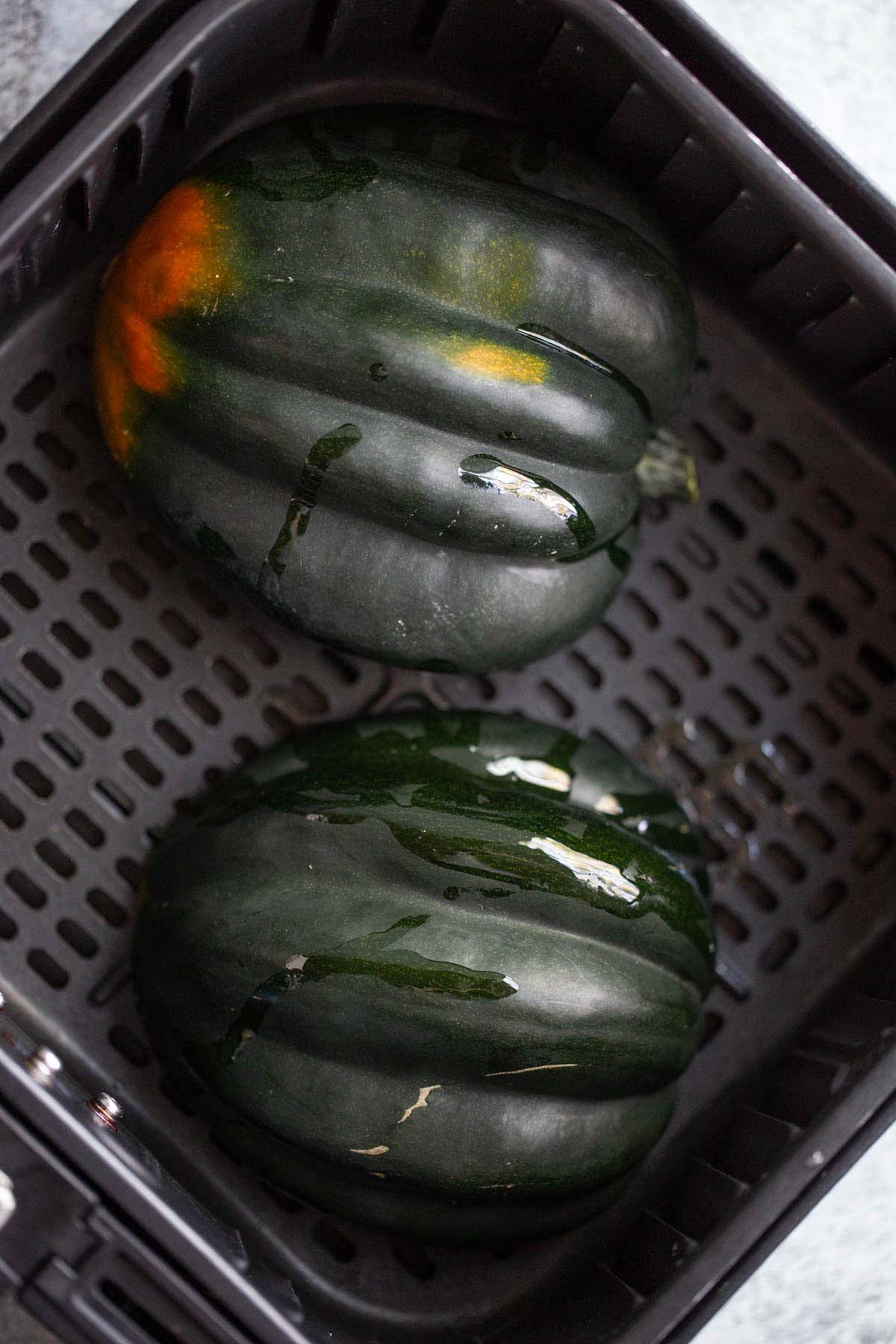 Acorn squash in air fryer basket.