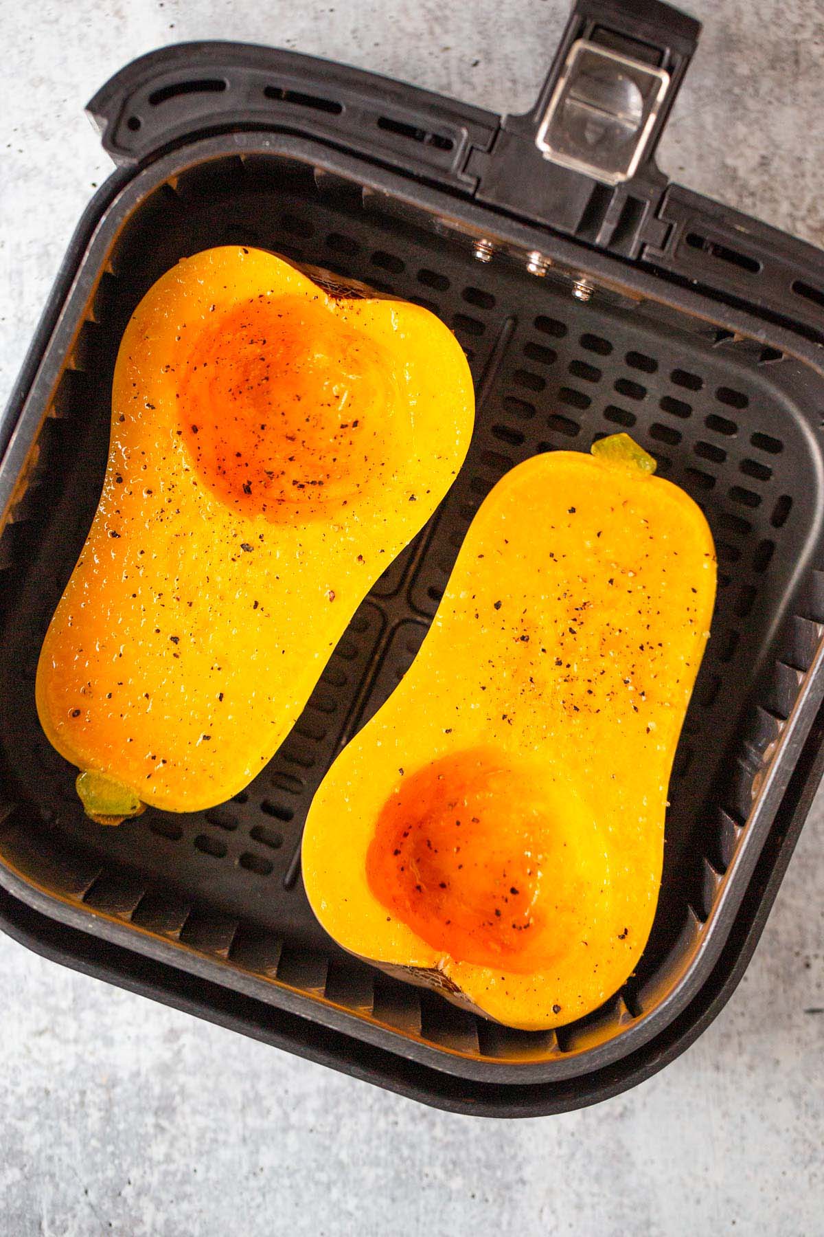 Uncooked butternut squash in air fryer.