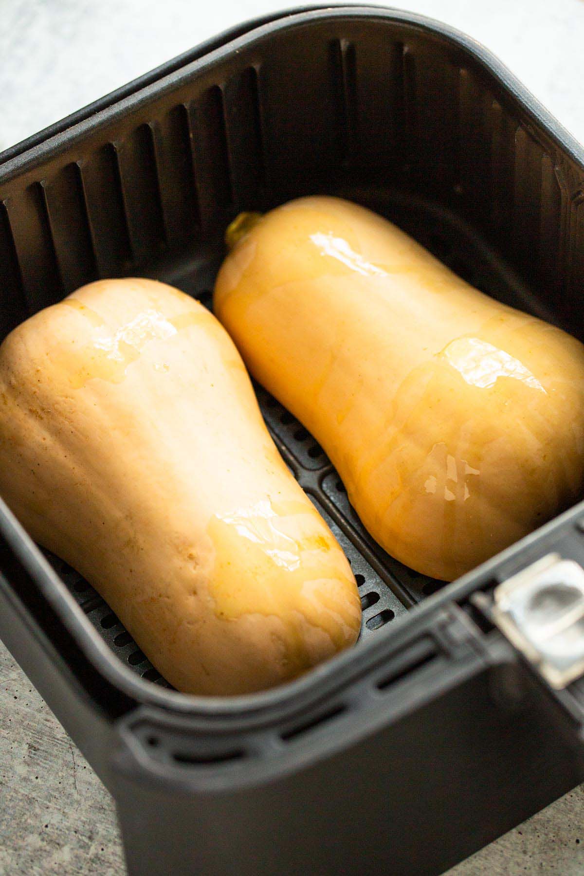 Uncooked butternut squash in air fryer.