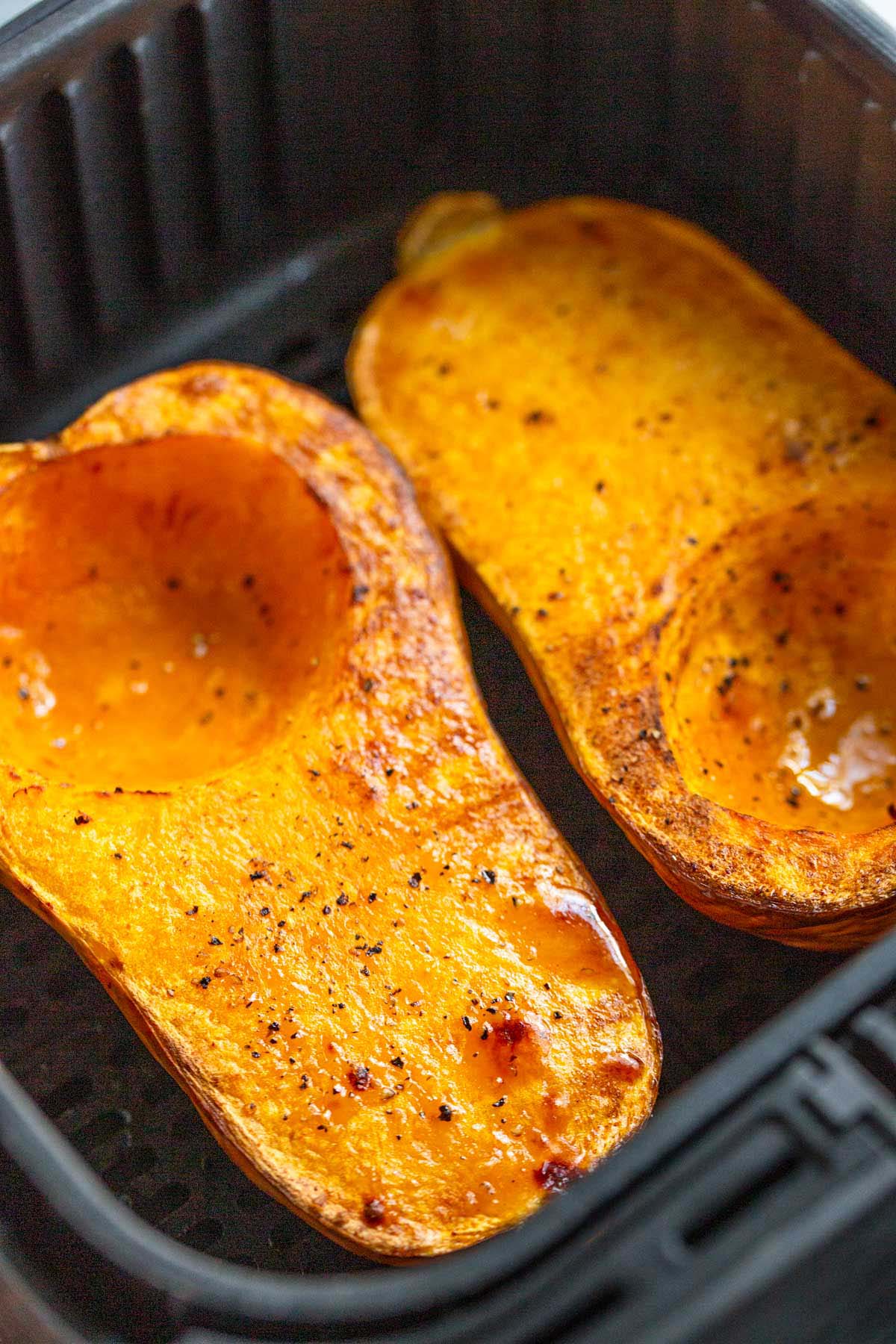 Cooked butternut squash halves in air fryer.