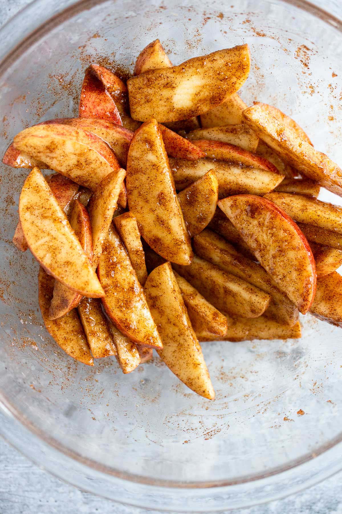 Apples tossed with butter and cinnamon in a bowl