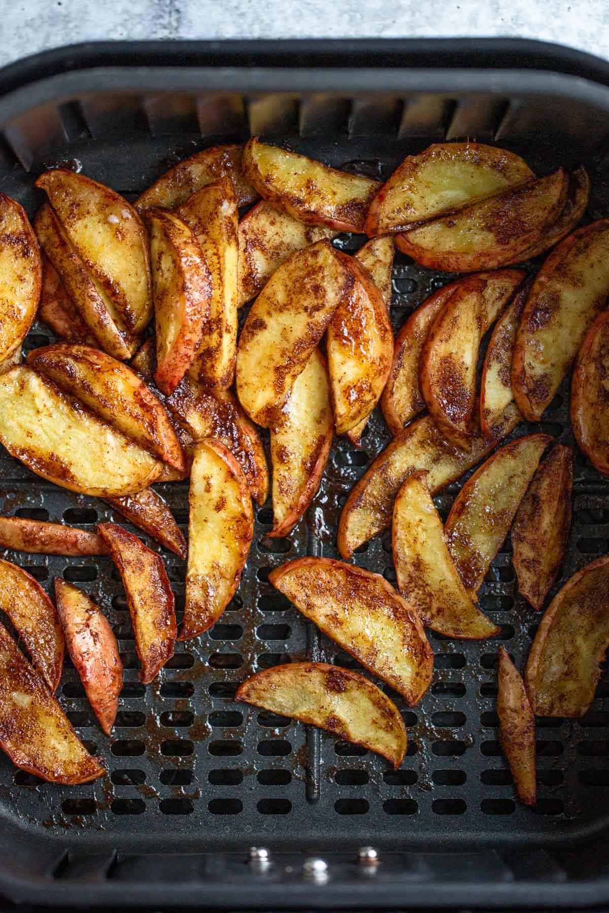 Cinnamon apples in air fryer basket.