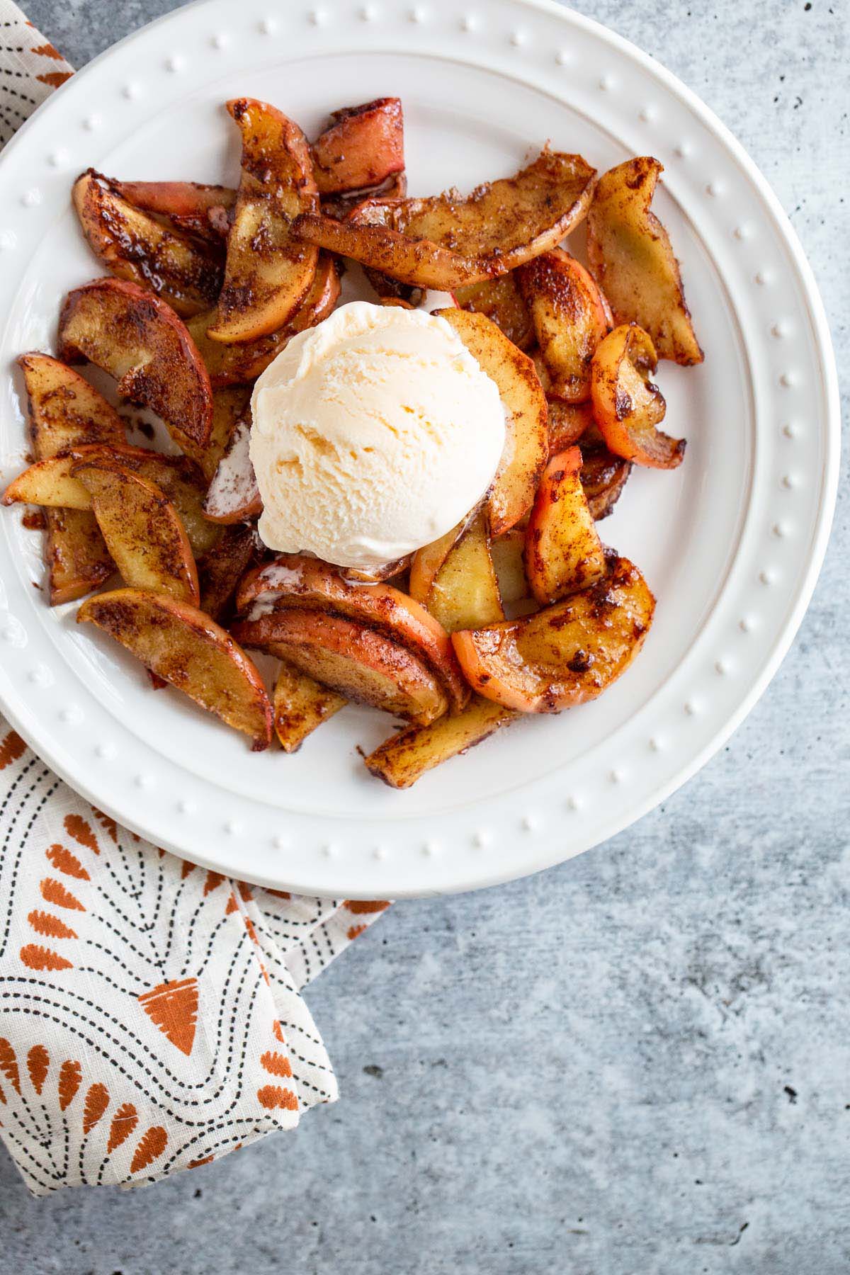 Cinnamon apples topped with ice cream.