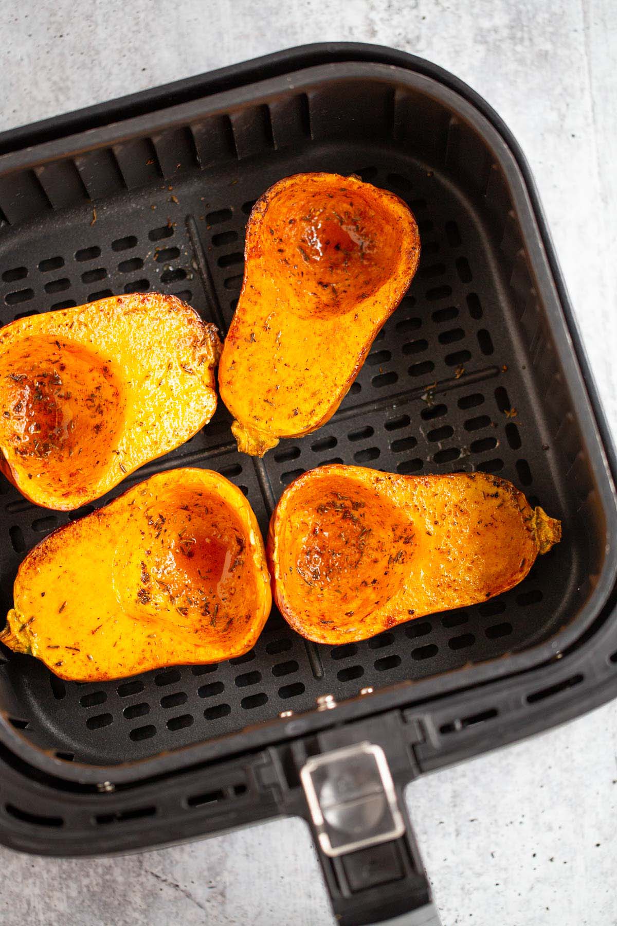 Honeynut squash in air fryer basket.