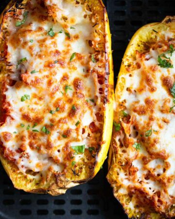 Cheesy spaghetti squash in air fryer basket.