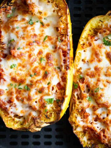 Cheesy spaghetti squash in air fryer basket.