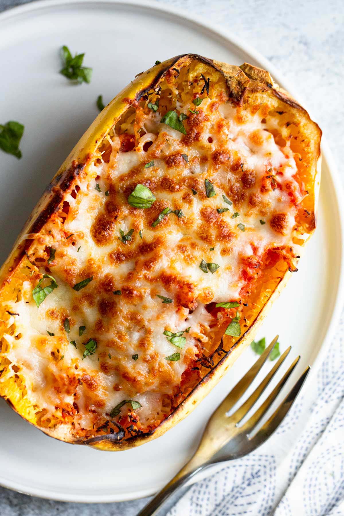 Cheesy spaghetti squash on a white plate.