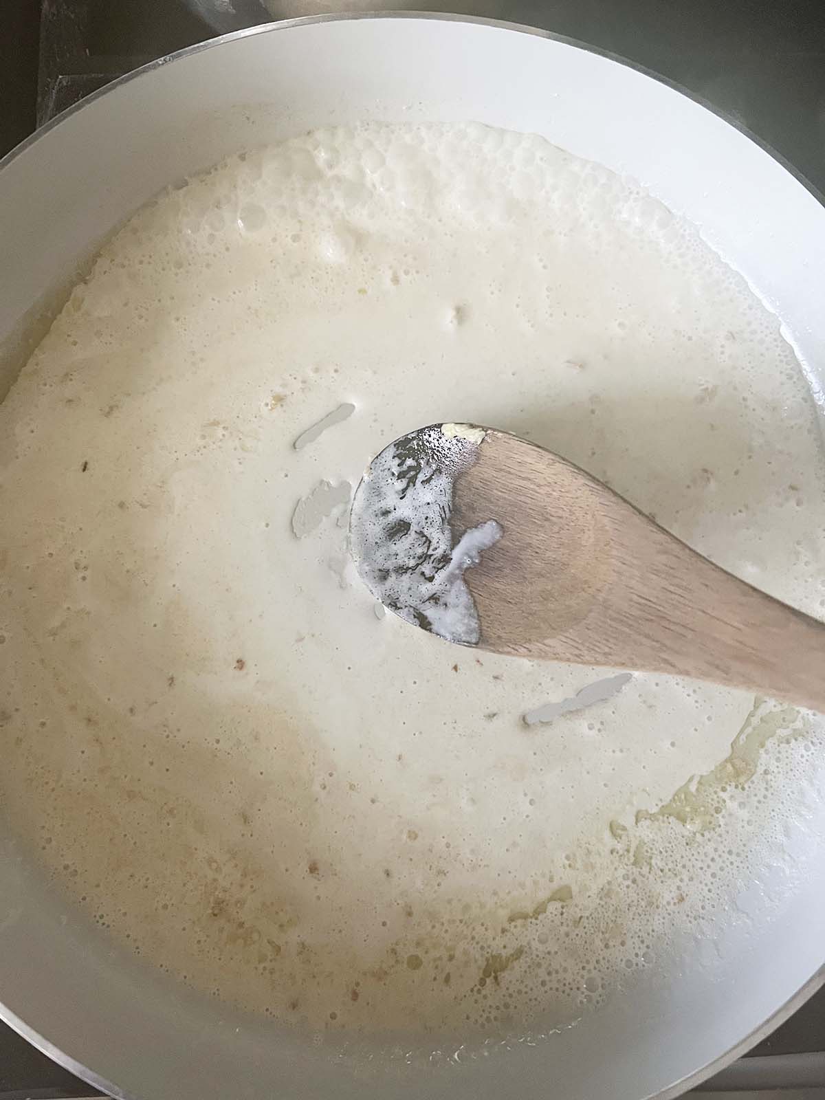 Stirring the creamy sauce.