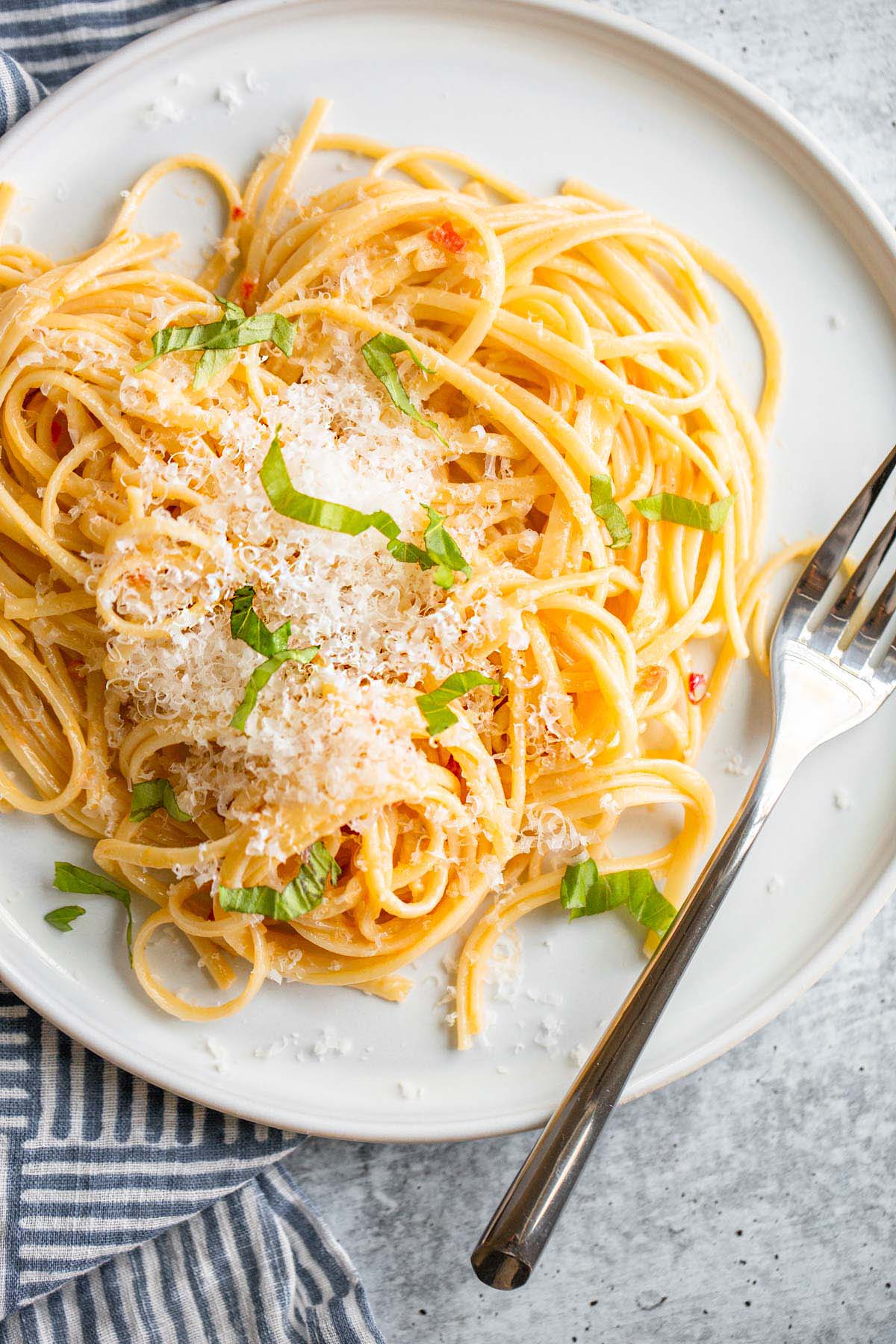 Creamy calabrian pasta on a plate topped with cheese and herbs.