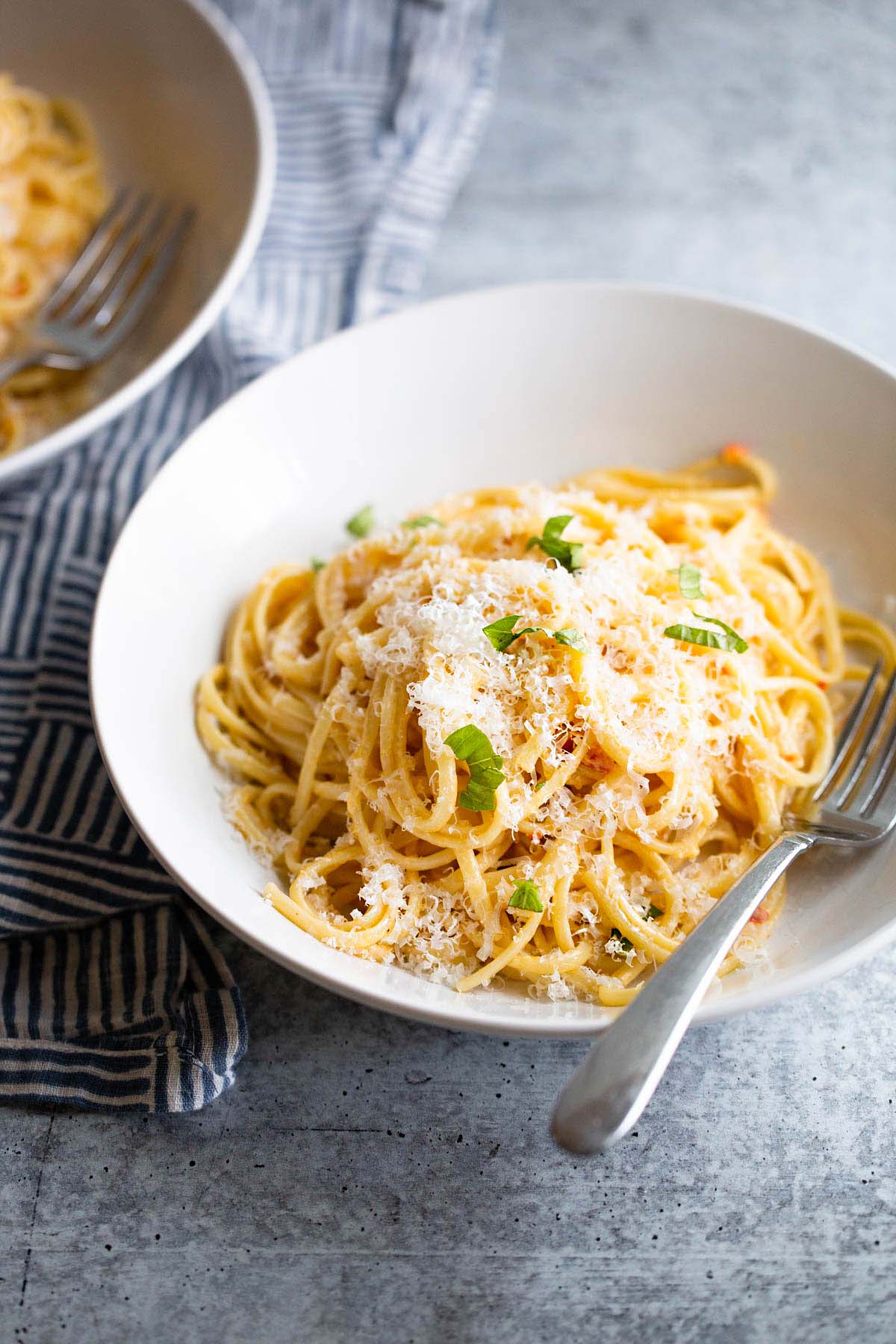 Creamy calabrian pasta topped with cheese and herbs.