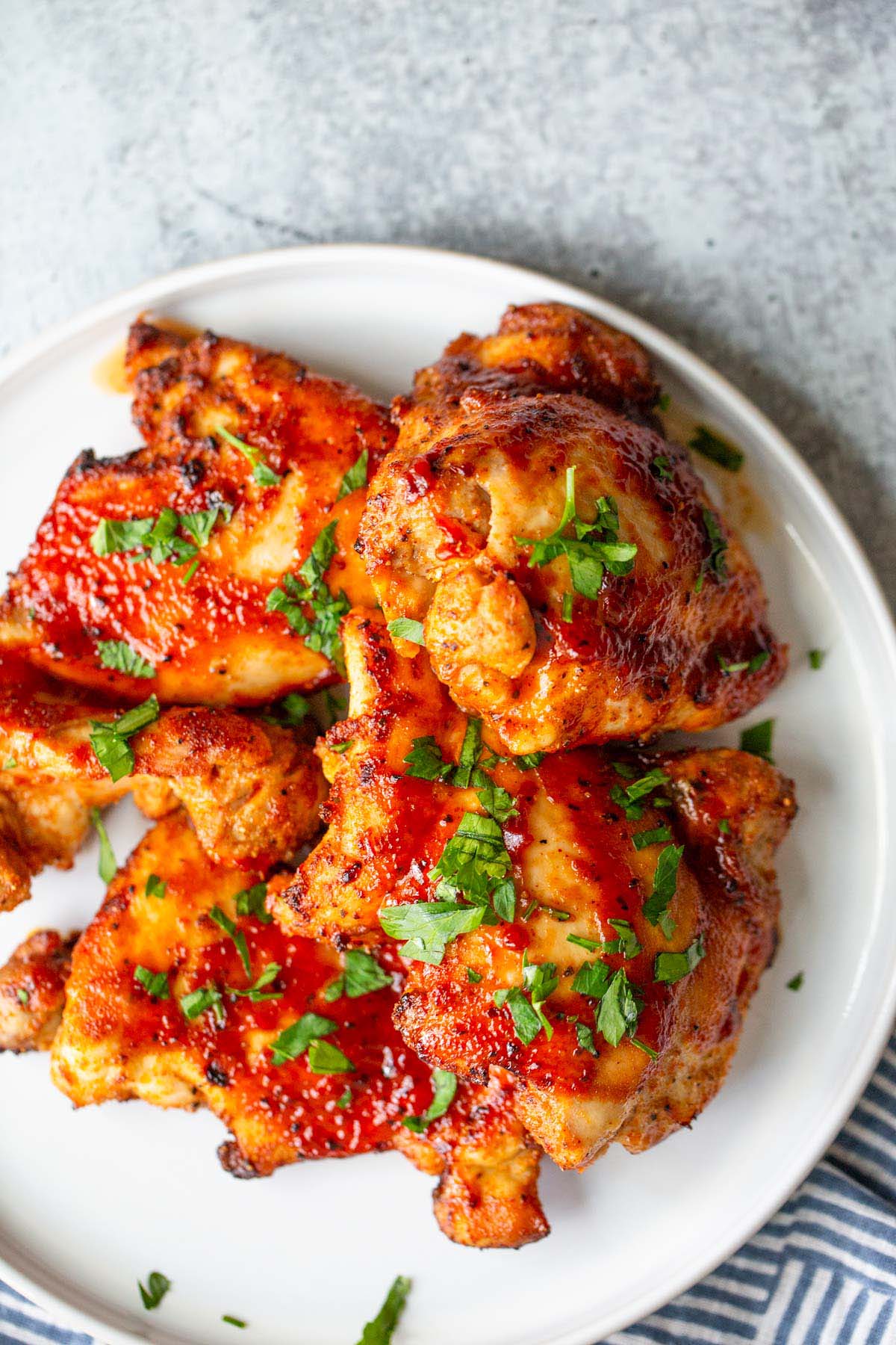 BBQ chicken thighs topped with chopped parsley.