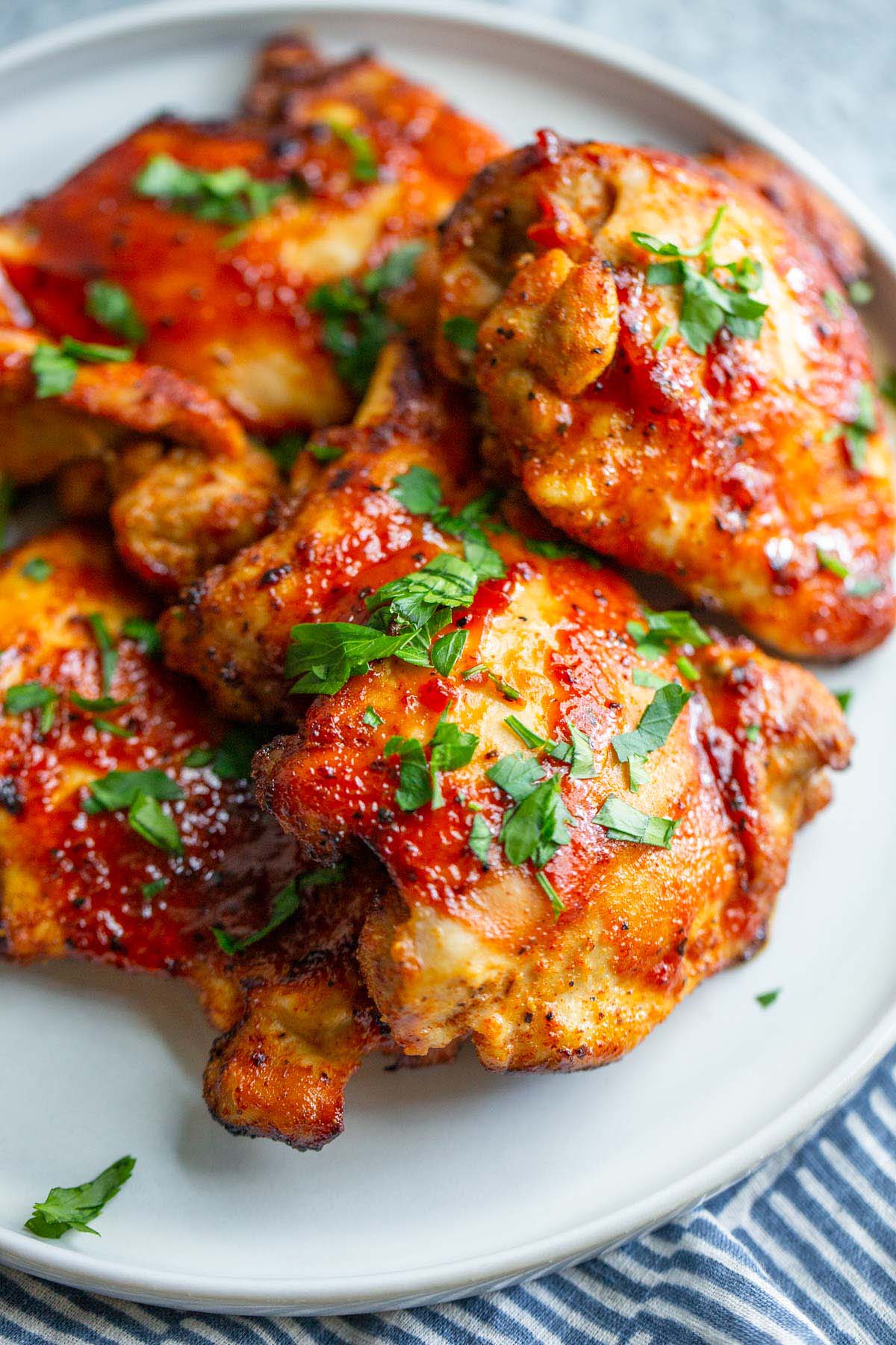 BBQ chicken thighs topped with chopped parsley.