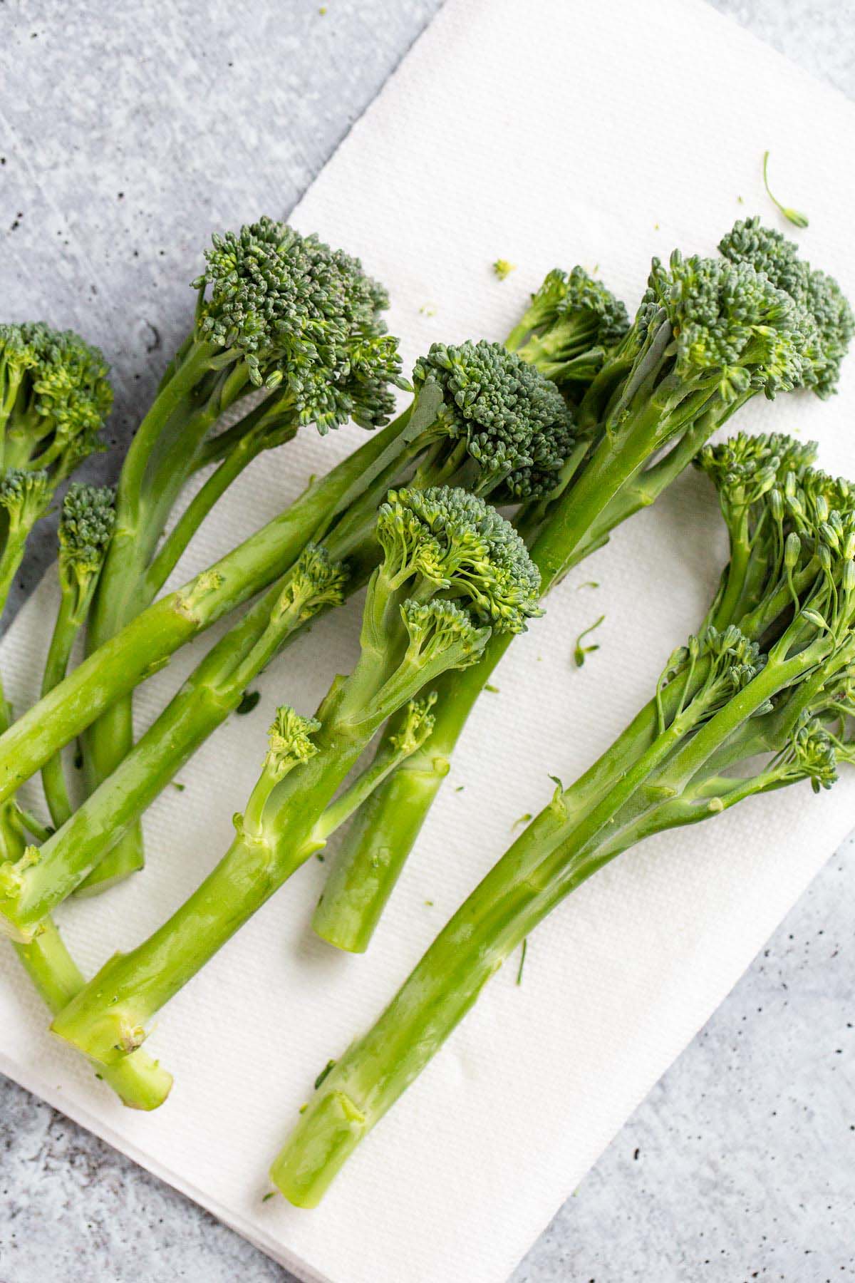 Raw broccolini on a paper towel.