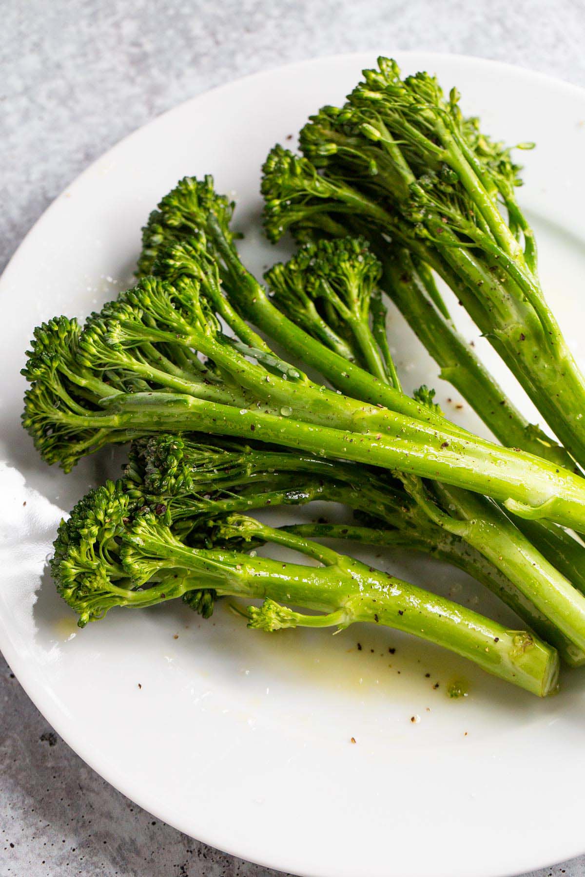 Broccolini on a plate with olive oil.