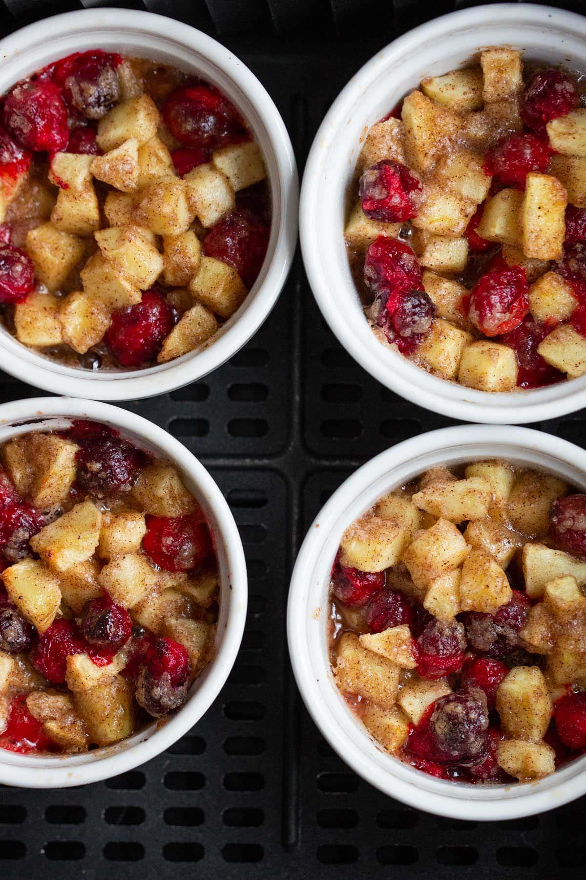 Cooked apple cranberry crisps in air fryer basket.