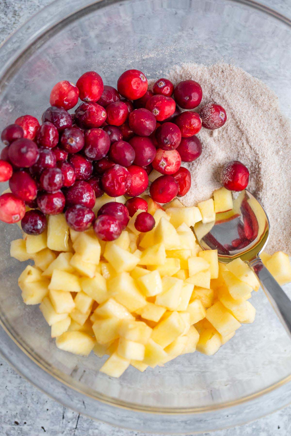Apples, cranberries, and sugar in a large bowl.