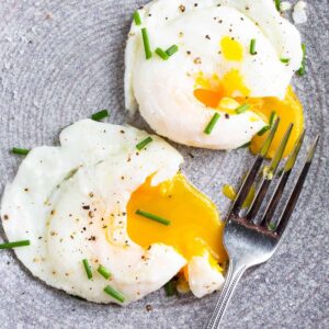 Air fryer poached eggs topped with chives.