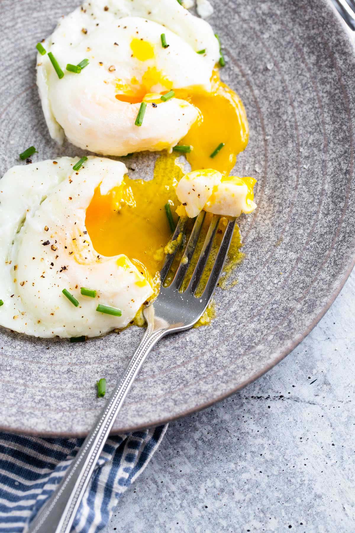 Two poached eggs with yolks broken.