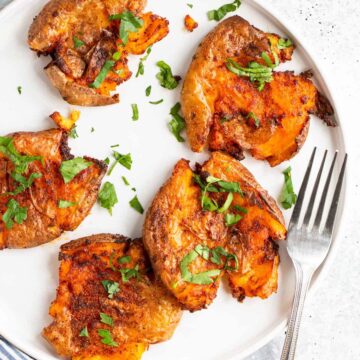 Air fryer smashed potatoes topped with parsley.