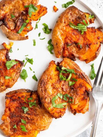 Air fryer smashed potatoes topped with parsley.