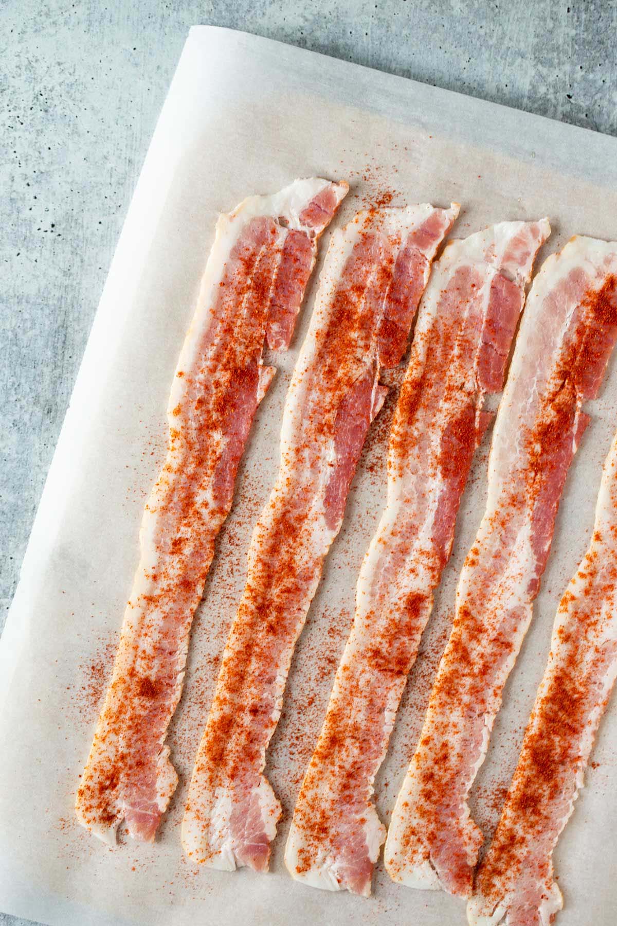 Bacon strips sprinkled with seasoning.