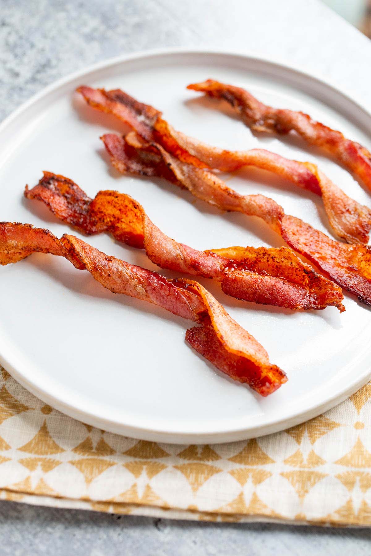 Twisted bacon on a white plate.