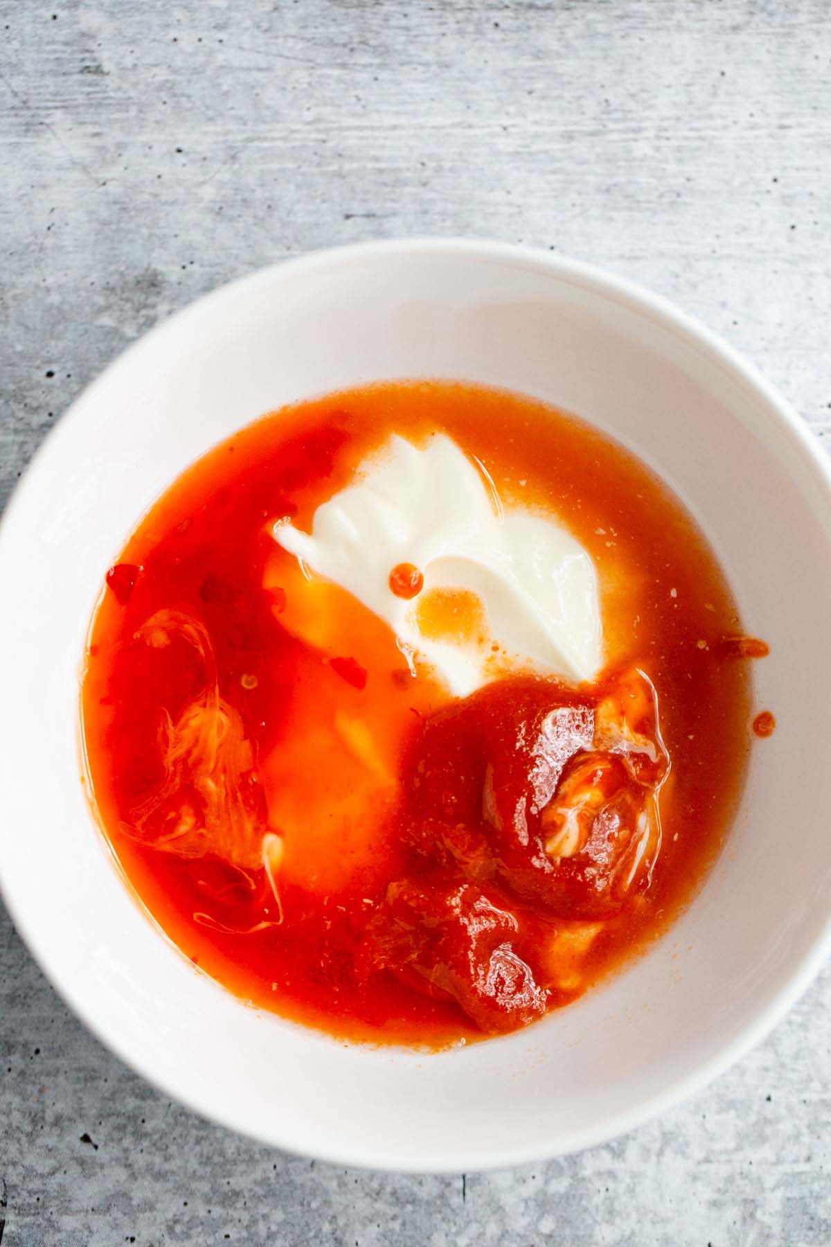 Ingredients for bang bang sauce in a white bowl.