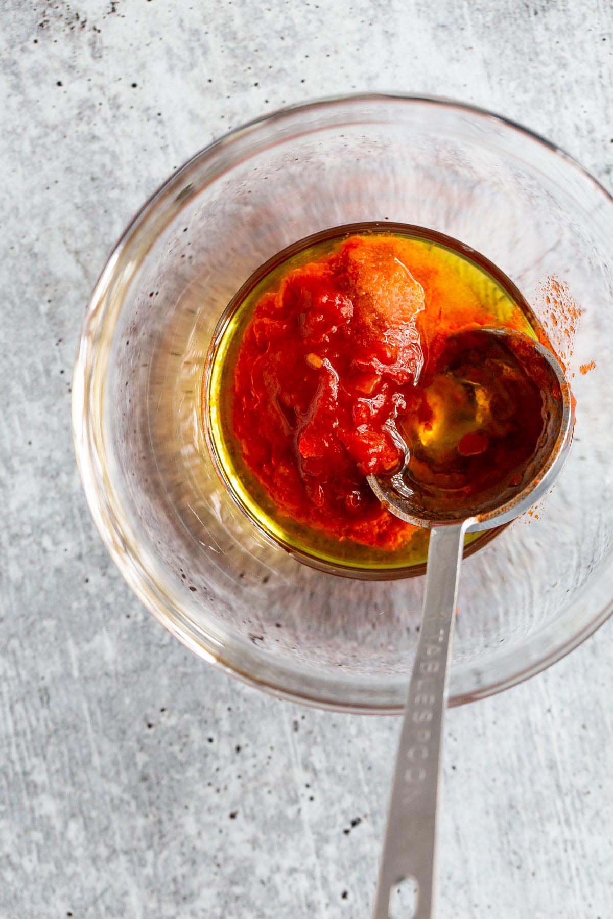 Harissa, olive oil, and salt in a small bowl.