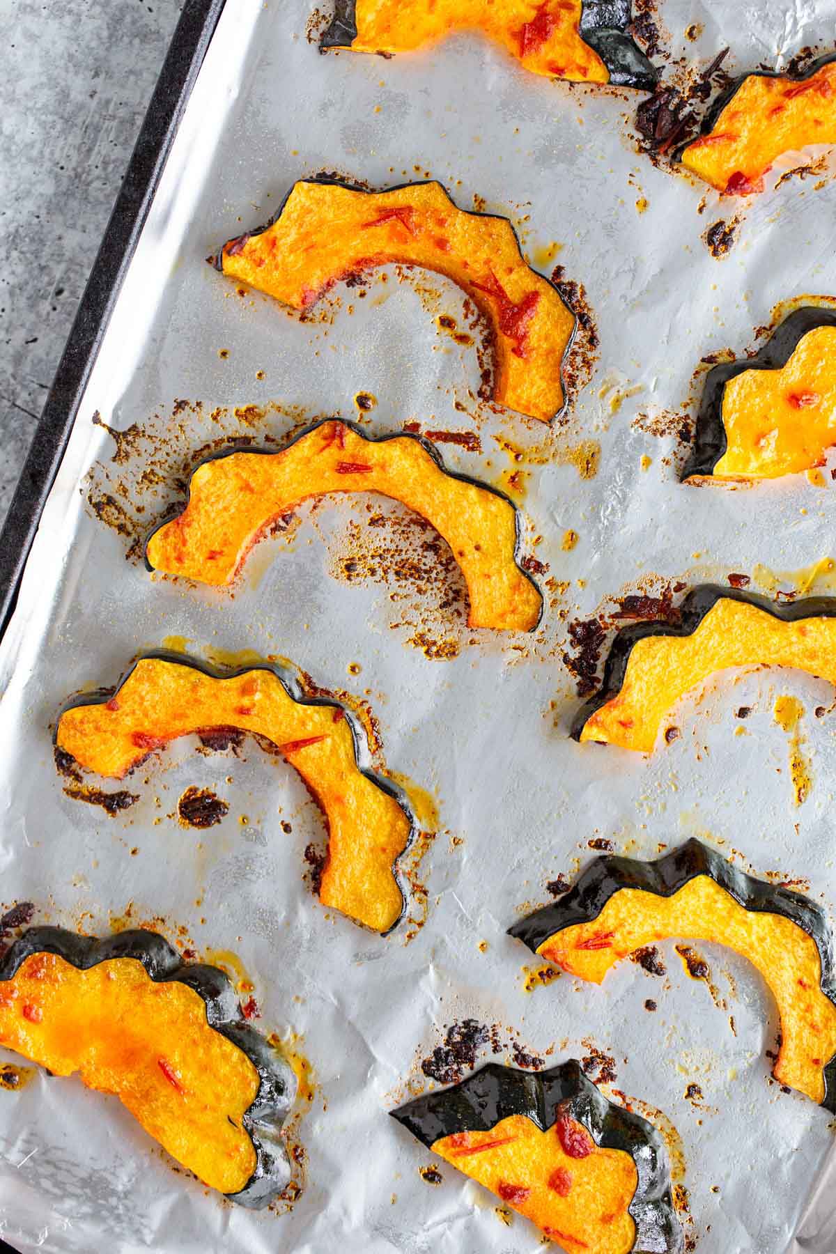 Roasted harissa acorn squash on a baking sheet.