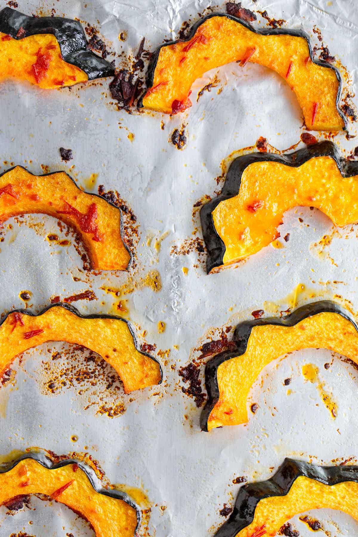 Roasted harissa acorn squash on a baking sheet.