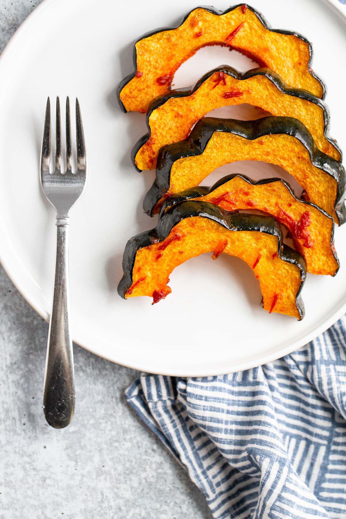 Harissa roasted acorn squash on a plate.