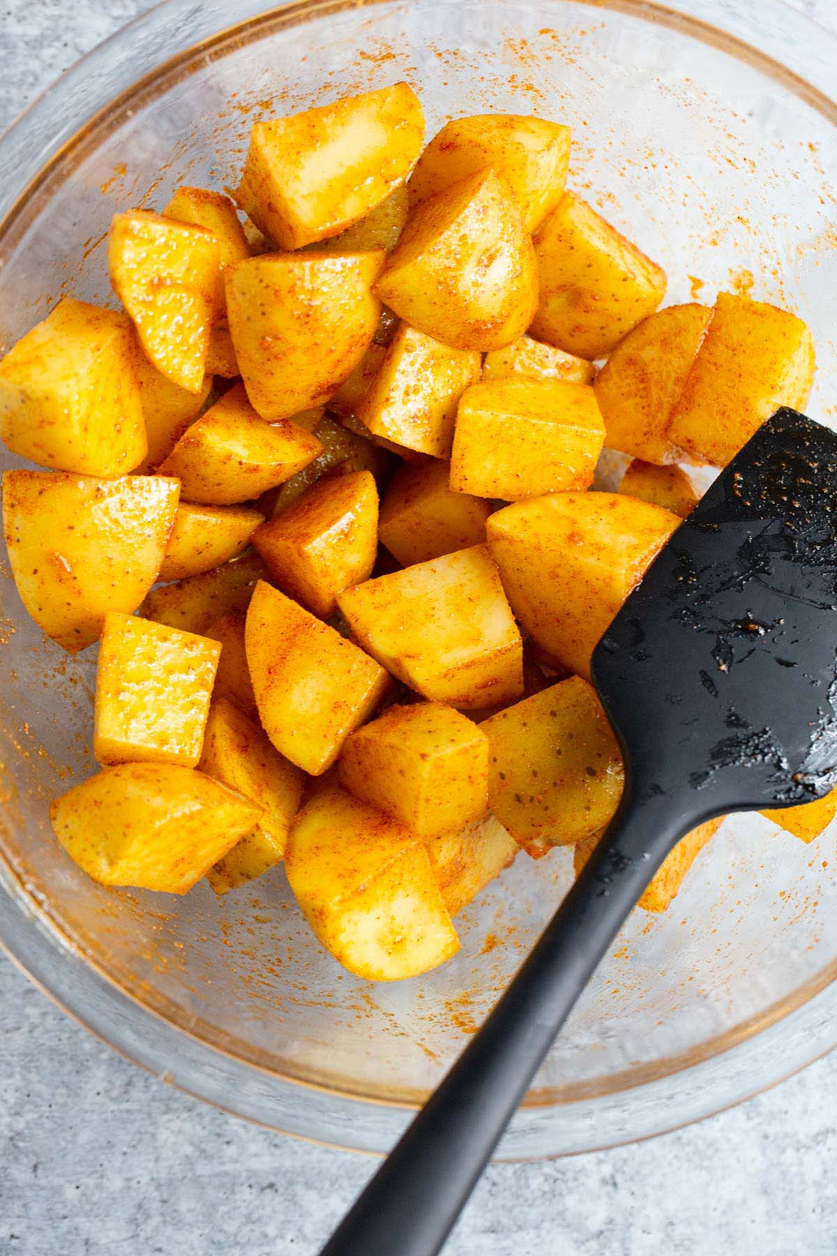 Uncooked potatoes in a glass bowl.