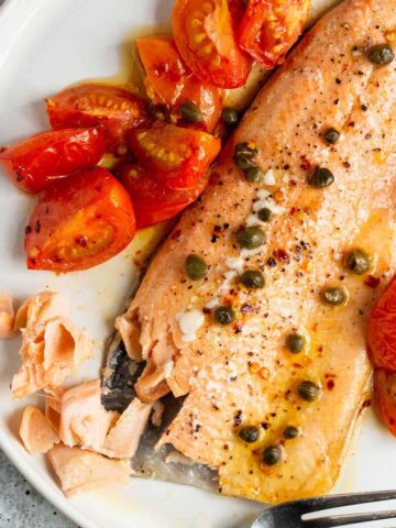 Baked rainbow trout with capers and tomatoes.